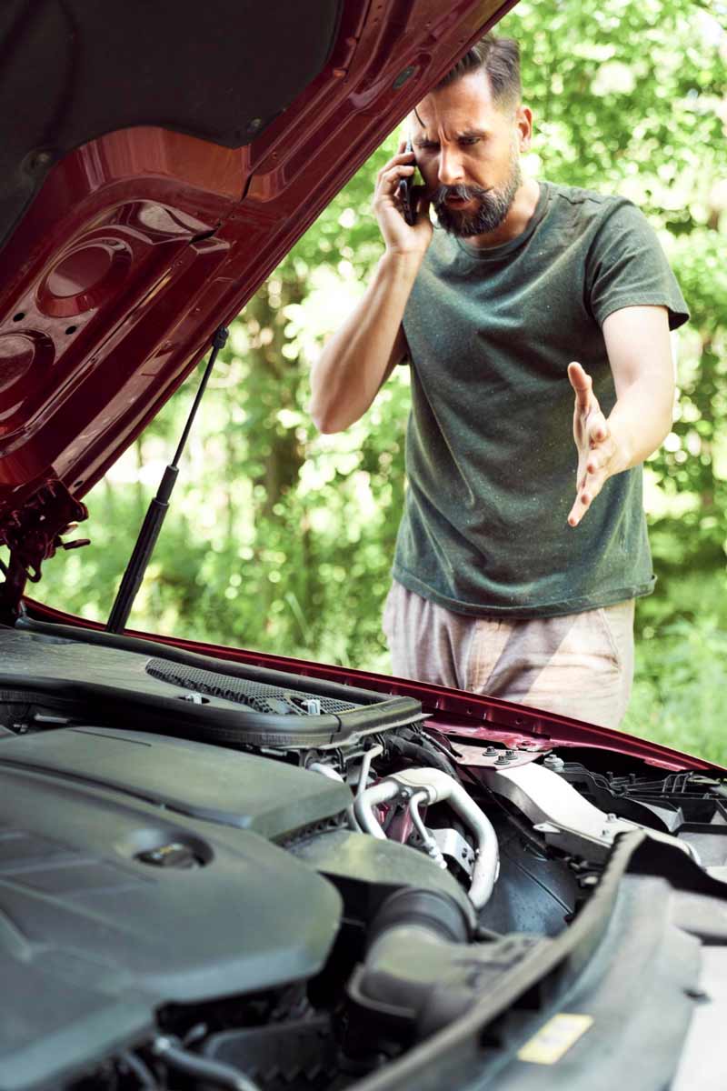 Junger Mann prüft Getriebeschaden bei Schrottauto Ankauf Meerbusch